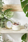 love spell intention candle is 4 oz of hand-poured soy wax in a glass jar with a metal lid open on shelf